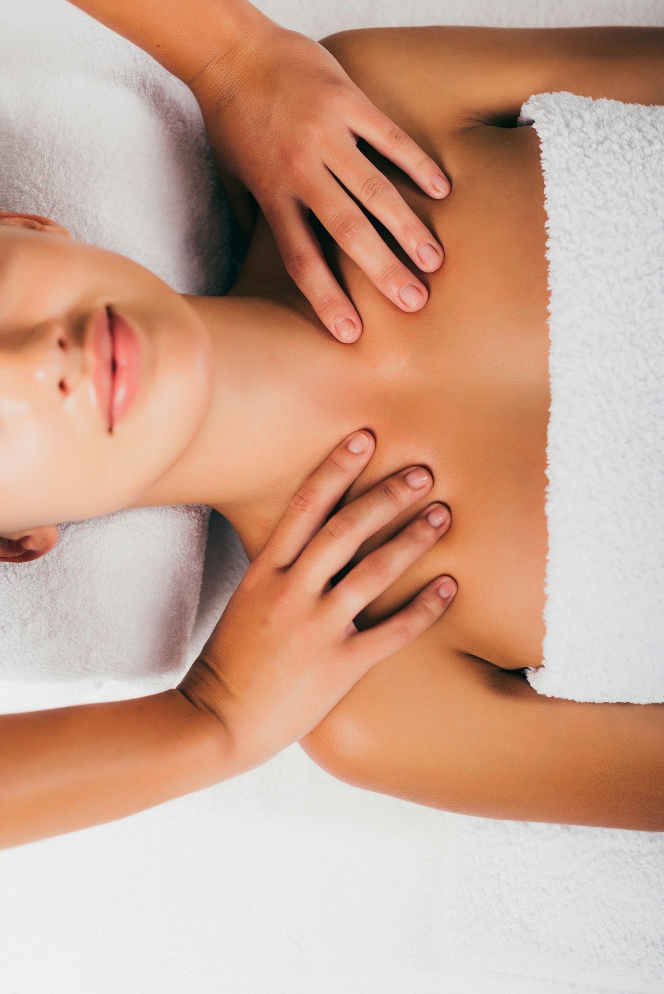 relaxing young woman having shoulders massage at spa salon