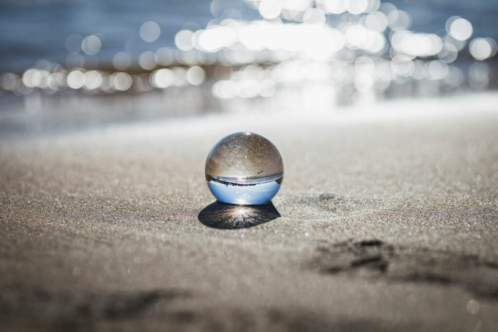 clear toy marble with reflection of seashore